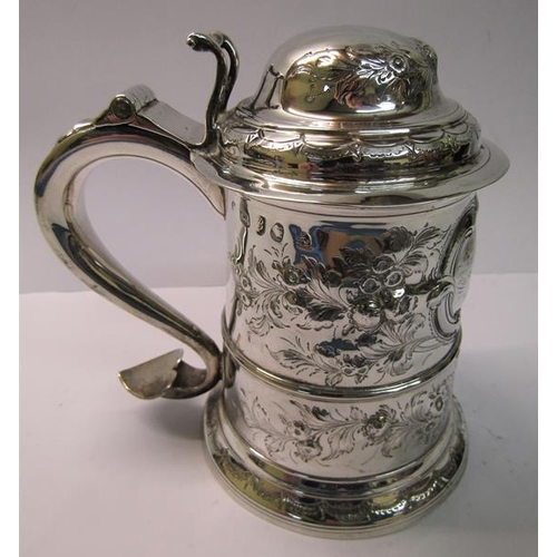 237 - A mid 18c silver tankard with scrolling handle and hinged domed cover with thumb piece and having la... 