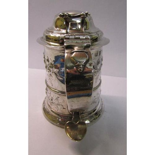 237 - A mid 18c silver tankard with scrolling handle and hinged domed cover with thumb piece and having la... 