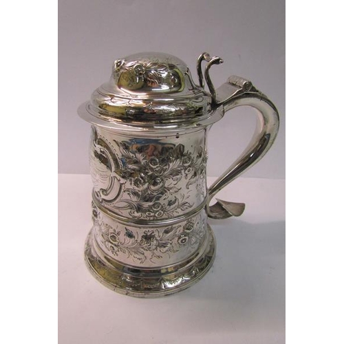 237 - A mid 18c silver tankard with scrolling handle and hinged domed cover with thumb piece and having la... 