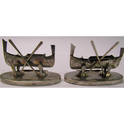 162 - A pair of Maltese silver menu card holders in the form of  boats, each with two oars supported on ov... 