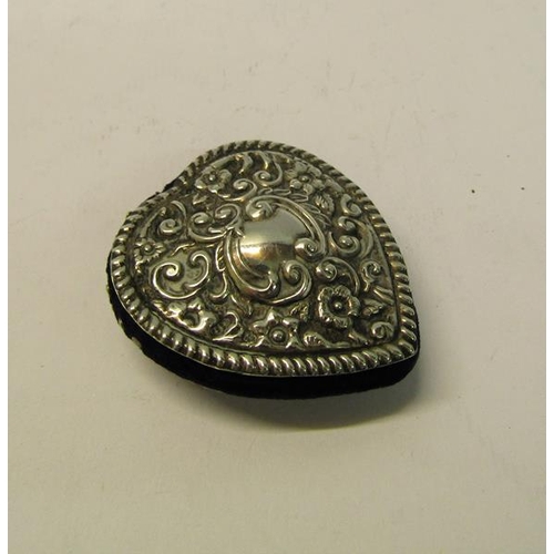 170 - An Edwardian silver pin cushion embossed and chased heart shaped form, makers mark for Henry Matthew... 