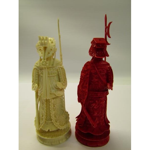 73 - Two 19c Chinese carved ivory chess pieces, both in the form of warriors, one white and one red stain... 