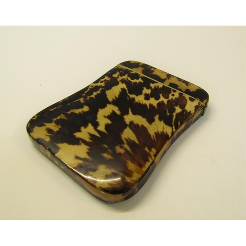 76 - A Victorian tortoiseshell visiting card case with ivory rims and being of waisted form, 8cm x 10cm.