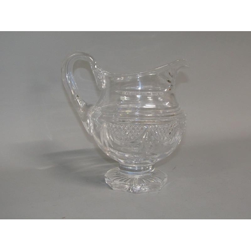 249 - An early 19c English cut glass jug with diamond cut and swag decoration, scrolling handle, supported... 