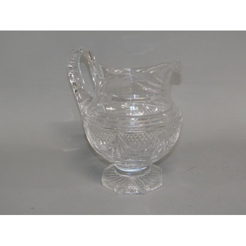 249 - An early 19c English cut glass jug with diamond cut and swag decoration, scrolling handle, supported... 