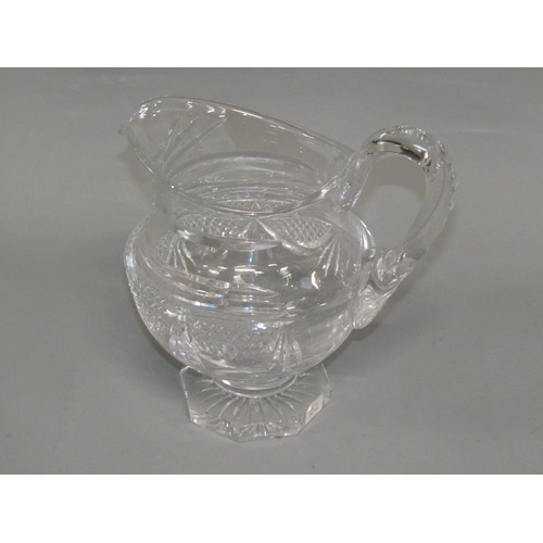 249 - An early 19c English cut glass jug with diamond cut and swag decoration, scrolling handle, supported... 