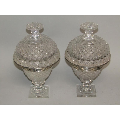 256 - A pair of early 19c cut glass bonbonnieres with lift off covers, having cut finials, the bowls with ... 