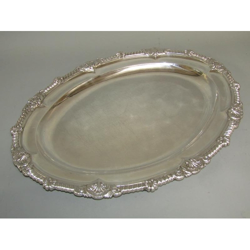 241 - A pair of late Georgian silver platters of oval form with raised and cast borders with gadroon, shel... 