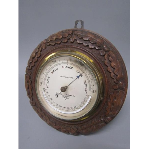 13 - An early 20c aneroid barometer by Negretti & Zambra in circular hardwood case carved with oak leaves... 