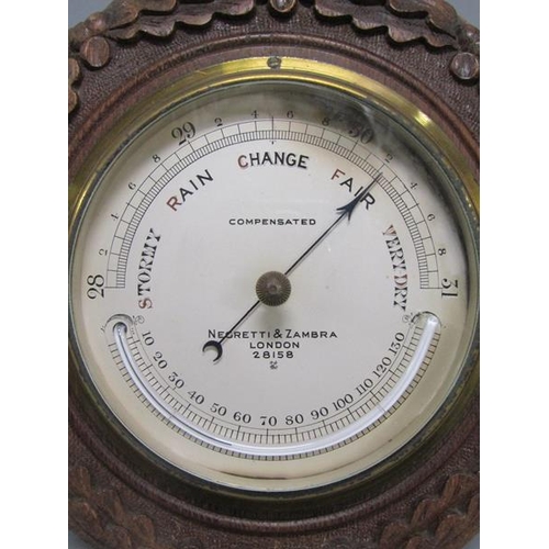 13 - An early 20c aneroid barometer by Negretti & Zambra in circular hardwood case carved with oak leaves... 