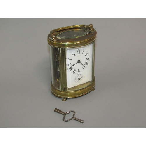 6 - A late 19c French carriage clock in glazed brass oval case.  The single train movement has a cylinde... 