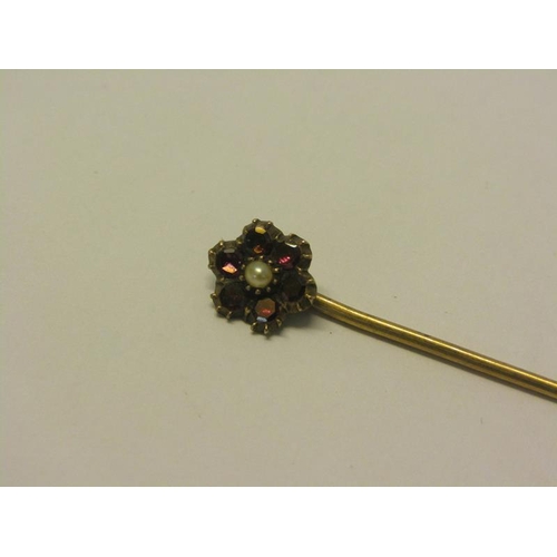 150 - A 19c gold stick pin with ruby daisy setting with seed pearl centre, 6cm l.