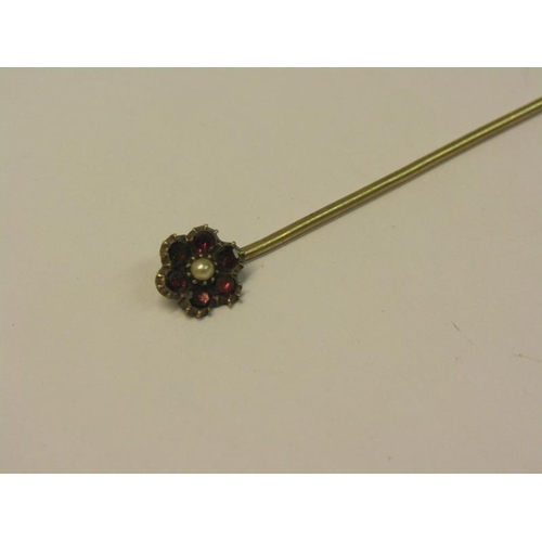 150 - A 19c gold stick pin with ruby daisy setting with seed pearl centre, 6cm l.