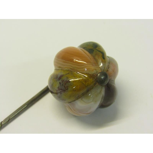 152 - An Edwardian white metal stick pin with a lobed globular naturally grained multi coloured agate term... 