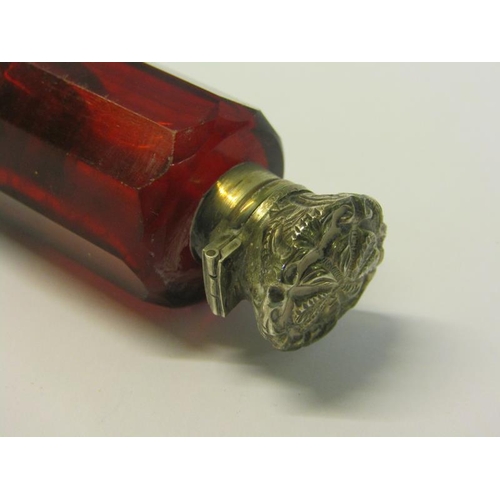 82 - A collection of three late 19c/early 20c cut ruby glass double ended scent bottles with silver embos... 