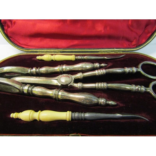 244 - A late 19c boxed set of silver plated nut cracks, a pair of grape scissors and a pair of bone handle... 