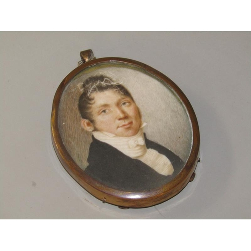 89 - An early 19c framed oval portrait miniature of a gentleman, he in black coat with a white collar, fr... 