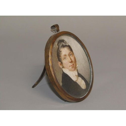 89 - An early 19c framed oval portrait miniature of a gentleman, he in black coat with a white collar, fr... 