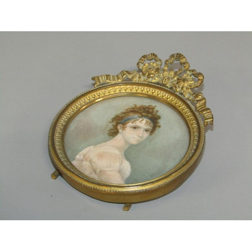 90 - A 19c circular miniature portrait of a lady, Mme. Recamier, framed and glazed, in a gilt cast metal ... 