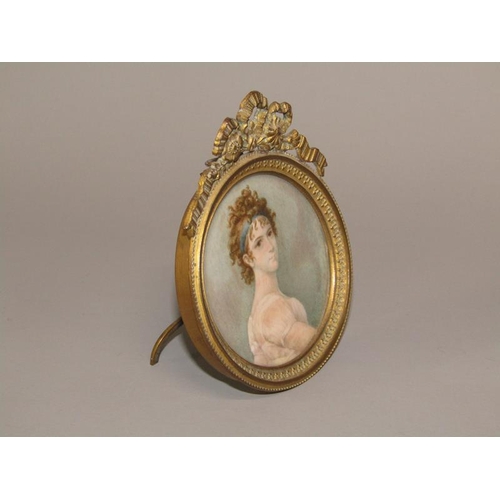 90 - A 19c circular miniature portrait of a lady, Mme. Recamier, framed and glazed, in a gilt cast metal ... 