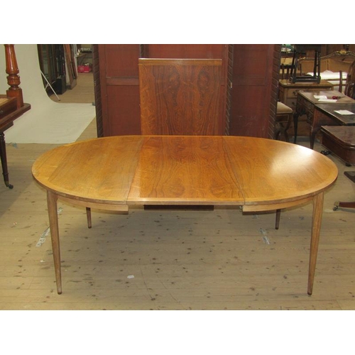 450 - A 1960/70's Rosegaarden veneered and crossbanded extending dining table with rounded end, supported ... 