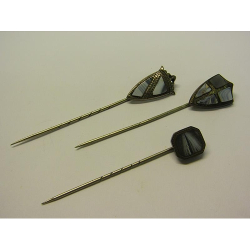 144 - A collection of three early 20c white metal stick pins, two of shield shaped form, all set with gree... 