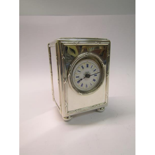 189 - A late Edwardian silver cased mantel clock with a French movement and having a white enamel decorate... 