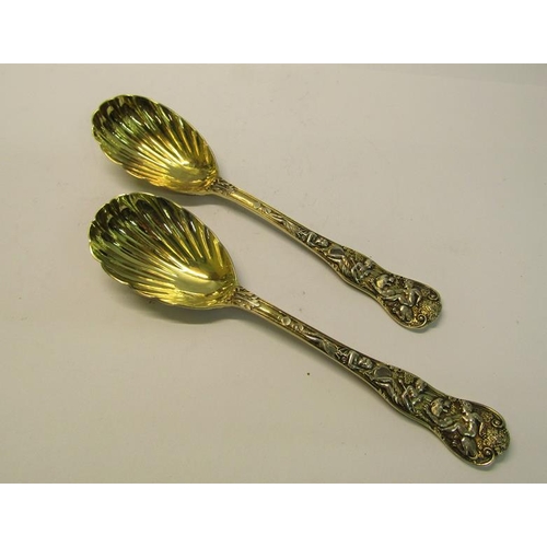 204 - A pair of late Victorian silver gilt serving spoons with shell shaped bowls, the handles cast with c... 