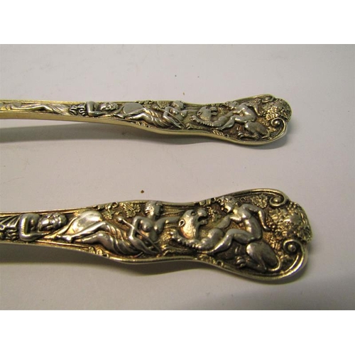 204 - A pair of late Victorian silver gilt serving spoons with shell shaped bowls, the handles cast with c... 