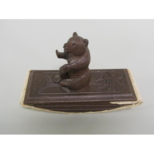 49 - Two carved wood Black Forest desk blotters, one mounted with a seated bear, the other with a Saint B... 