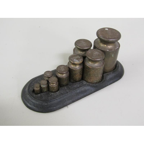 1240 - TWO SETS OF WEIGHTS IN CAST IRONS STANDS, LARGEST STAND 20CM L