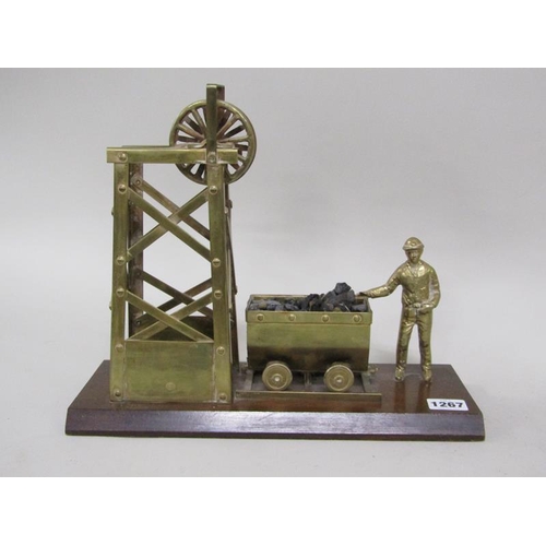 1267 - BRASS MINERS ORNAMENT ON WOODEN BASE, 33CM W; FIGURE