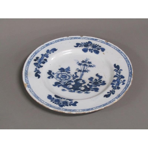 225 - An early 18c Delft blue and white plate, decorated with flowers and foliage, 26cm diam.