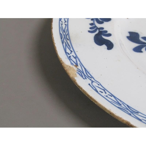 225 - An early 18c Delft blue and white plate, decorated with flowers and foliage, 26cm diam.