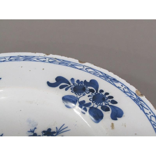 225 - An early 18c Delft blue and white plate, decorated with flowers and foliage, 26cm diam.