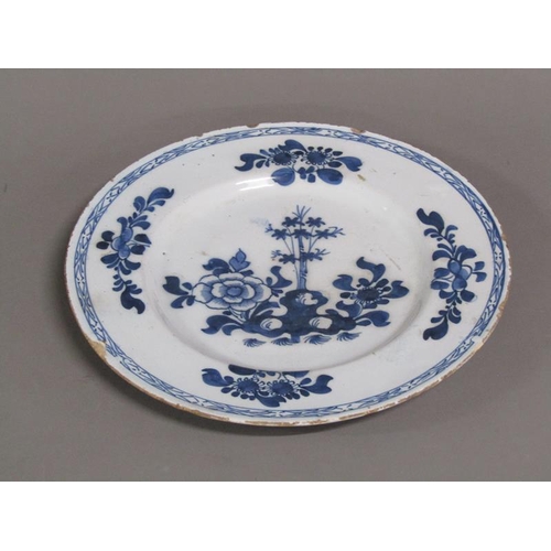 225 - An early 18c Delft blue and white plate, decorated with flowers and foliage, 26cm diam.