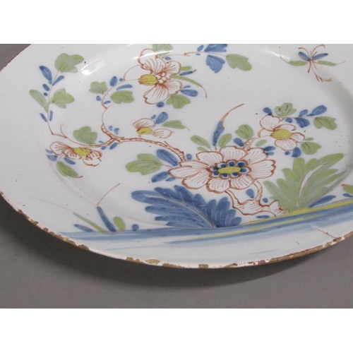 226 - An 18c Delft polychrome dish of circular form, decorated with flowers and foliage, 33cm diam.