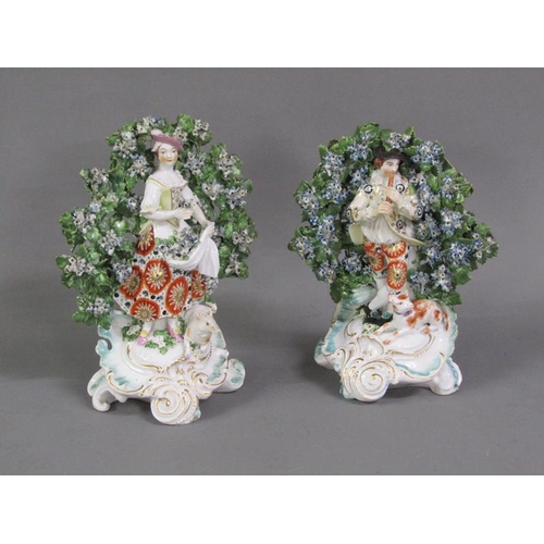 228 - A pair of Chelsea bocage figures of a shepherd and shepherdess, in gilt and floral costumes, a dog a... 