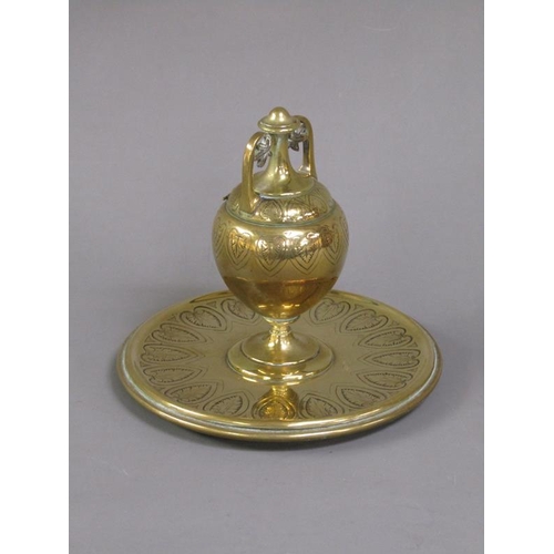 27 - A Victorian brass inkwell of ovoid form with a hinged domed cover supported on a circular base, lapp... 