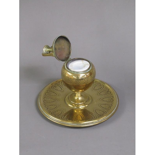 27 - A Victorian brass inkwell of ovoid form with a hinged domed cover supported on a circular base, lapp... 