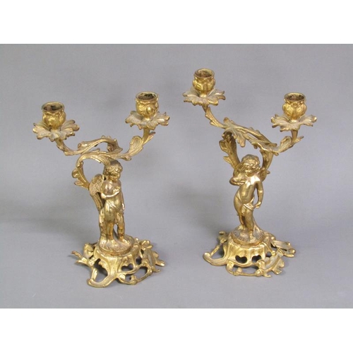 28 - A pair of late 19c rococo ormolu figurative two branch candelabra with cherub columns, 28cm h.