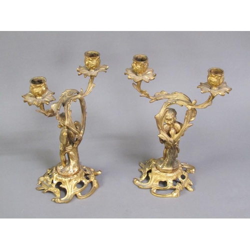 28 - A pair of late 19c rococo ormolu figurative two branch candelabra with cherub columns, 28cm h.