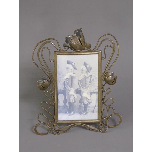 29 - An Art Nouveau brass easel photograph frame with an open scrolling floral mount, 25cm h, 20cm w over... 