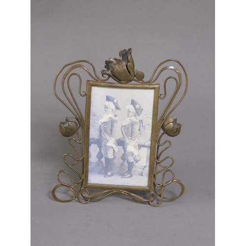 29 - An Art Nouveau brass easel photograph frame with an open scrolling floral mount, 25cm h, 20cm w over... 