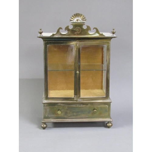 36 - A 19c brass table top cabinet with glass windows and enclosed by two hinged doors over a base fitted... 