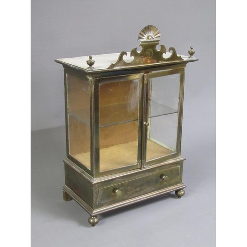 36 - A 19c brass table top cabinet with glass windows and enclosed by two hinged doors over a base fitted... 