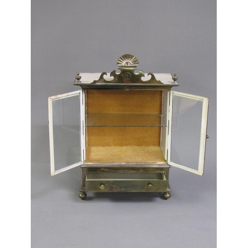 36 - A 19c brass table top cabinet with glass windows and enclosed by two hinged doors over a base fitted... 