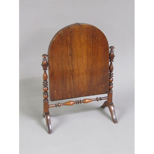 47 - A Regency period rosewood toilet glass, the arched mirror with a line inlaid border, supported on ri... 