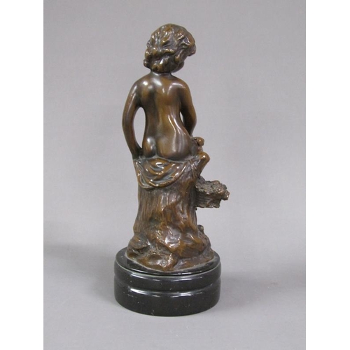 71 - A late 19c/early 20c patinated bronze figure of a young child seated upon a tree stump with a basket... 