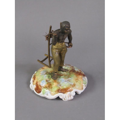 74 - A late 19c patinated metal figure of a West Indian bale carrier supported on a ceramic plinth, figur... 